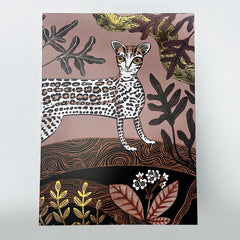 A greeting card with an illustration of an ocelot in the forest at sunrise. The card features gold foiling and is suitable for various occasions.