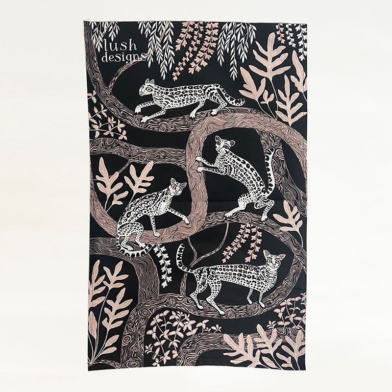 Ocelot Tea Towel tea towel with design of ocelots in black and white with pale pink trees on a black background