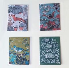 Four decorative greetings cards with animal and nature-themed designs.