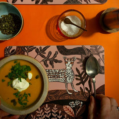ocelot print table mat on orange table with bowl of soup