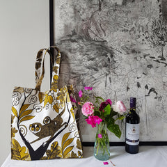 Cotton tote bag with print of Lorises next to bunch of pink flowers and bottle of red wine