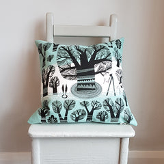 Lush Designs tree print cushion with silhouettes of trees and garden tools in black on teal and white