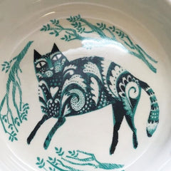 Picture of inside of cat feeding bowl printed with recumbent cat in black and turquoise