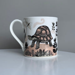 White mug with turtle design on a gray background