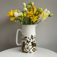 jug decorated with cats filled with yellow flowers