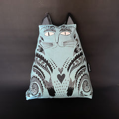 A cushion designed to resemble a blue cat with decorative patterns, complete with cat ears and a tail.