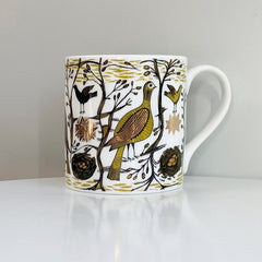 Lush Designs mug with a pattern of small birds and plants with gold lustre