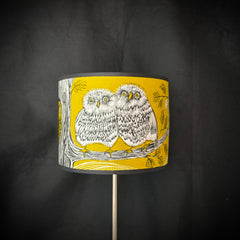 Lampshade with owl design on a yellow background against a dark gray background