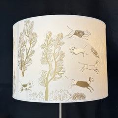 Lampshade with nature-themed design featuring trees and animals on a black background