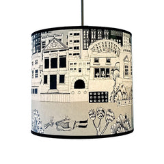 lampshade with print of black and grey buildings and skeleton lying under water 
