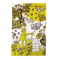 Lush Designs greeny yellow and black print on a tea towel featuring beekeeper smoking her hive and bees in a garden
