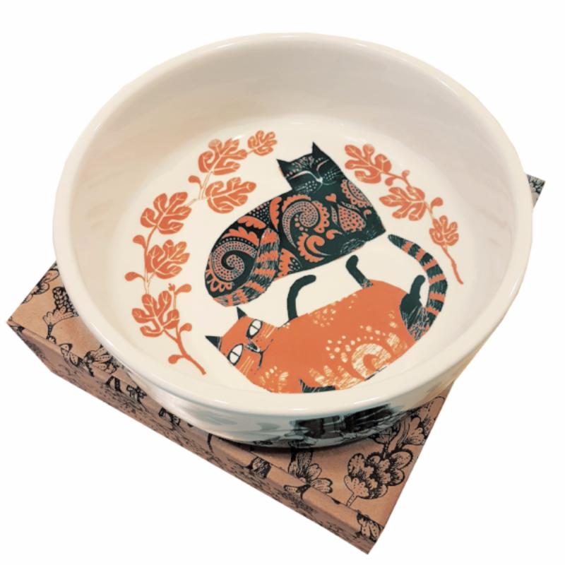 Lush designs orange and black cat bowl with two cats illustrated on it, sitting on a gift box