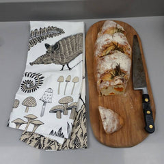 Lush Designs wild boar print tea towel shown here with a loaf of crusty bread