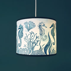 blue seahorse print lampshade against a dark blue wall