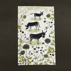 Lush Designs donkey tea towel photographed on a dark green background