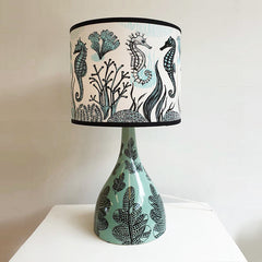 Lush Designs pale green ceramic lamp base with print of leaves in black, paired with seahorse print lampshade