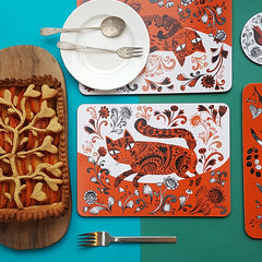 Tablw set with orange and black and white printed cat design mats and a fancy fruit pie